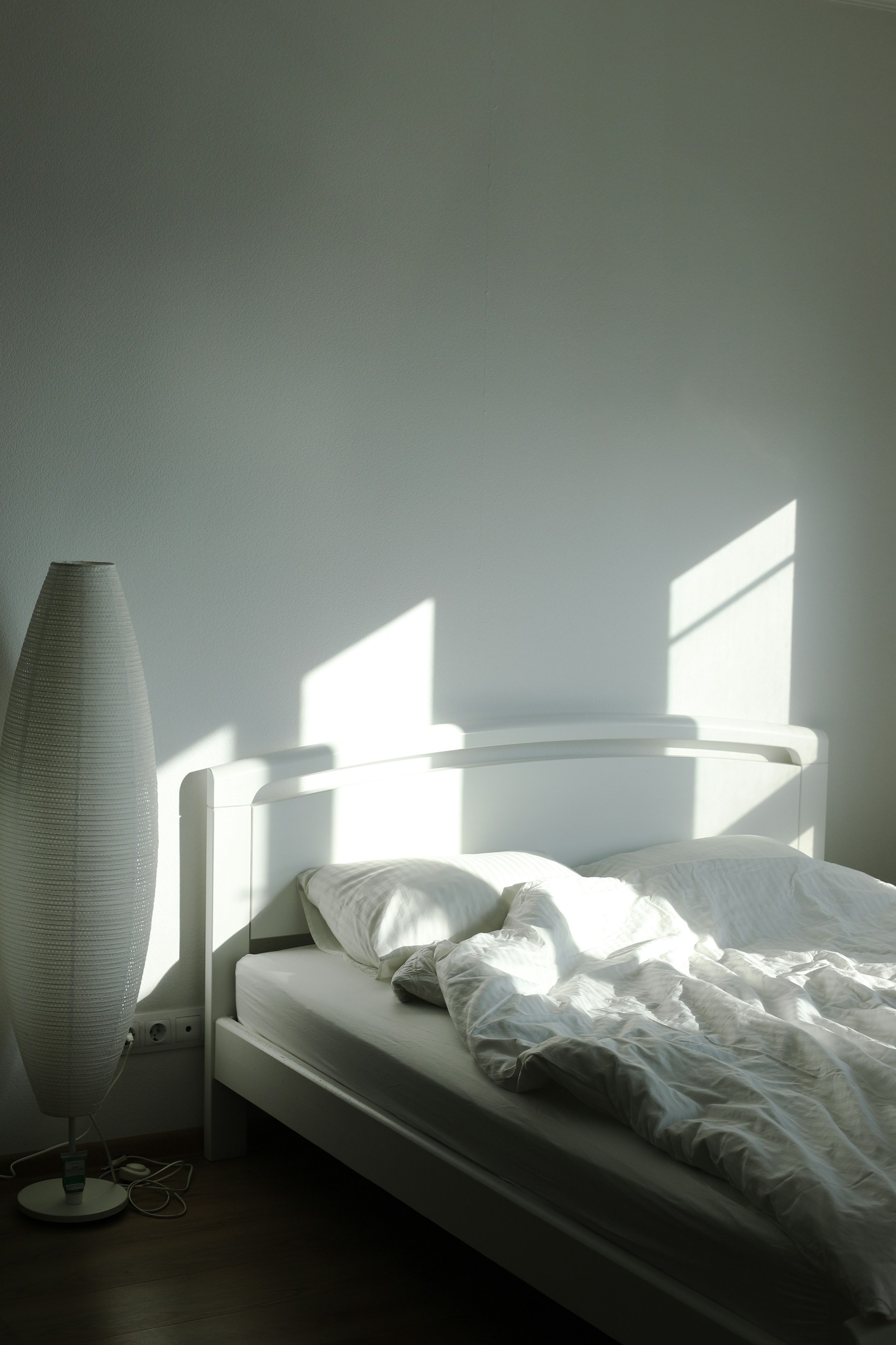 Lit blanc éclairé par une douce lumière matinale