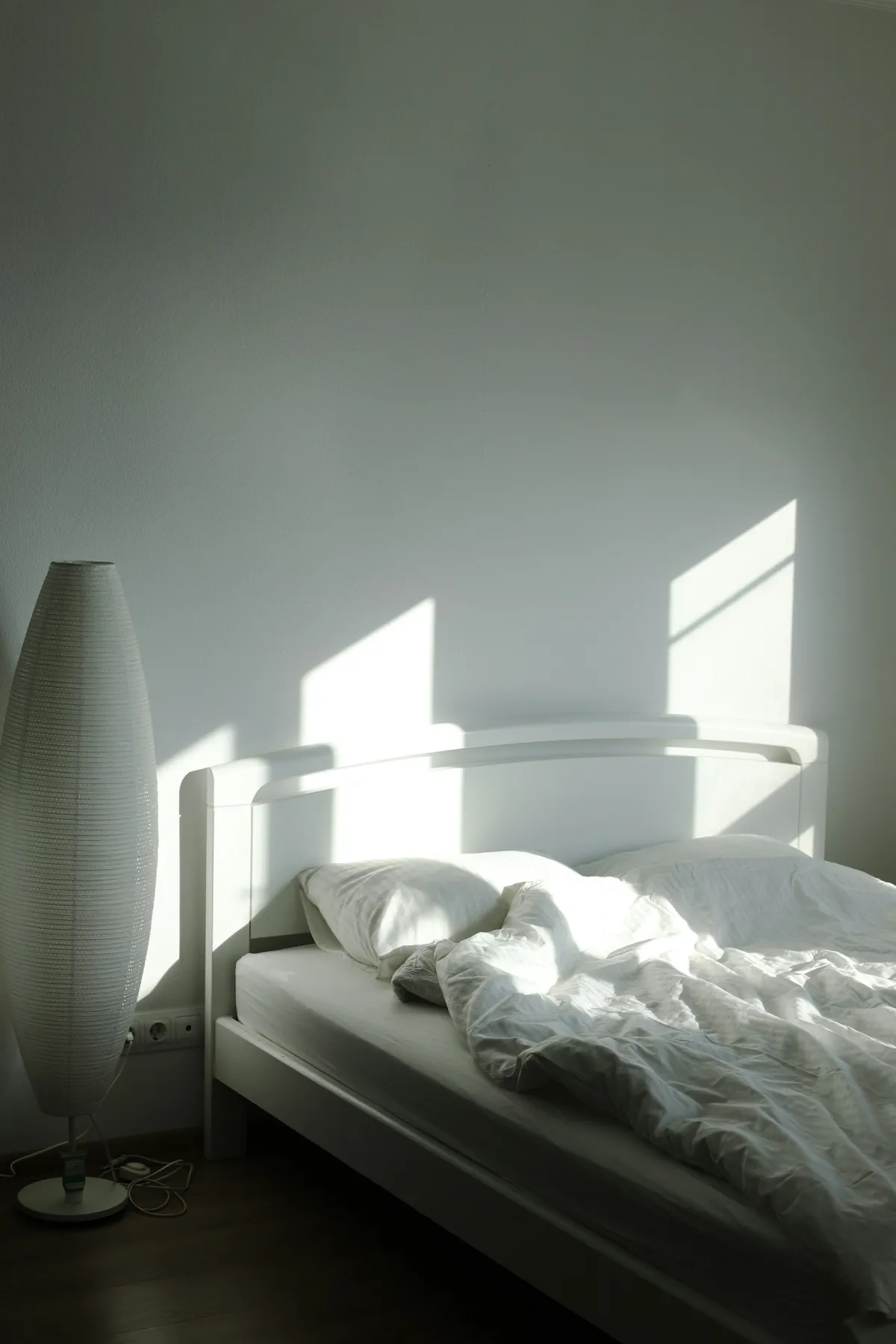 Lit blanc éclairé par une douce lumière matinale